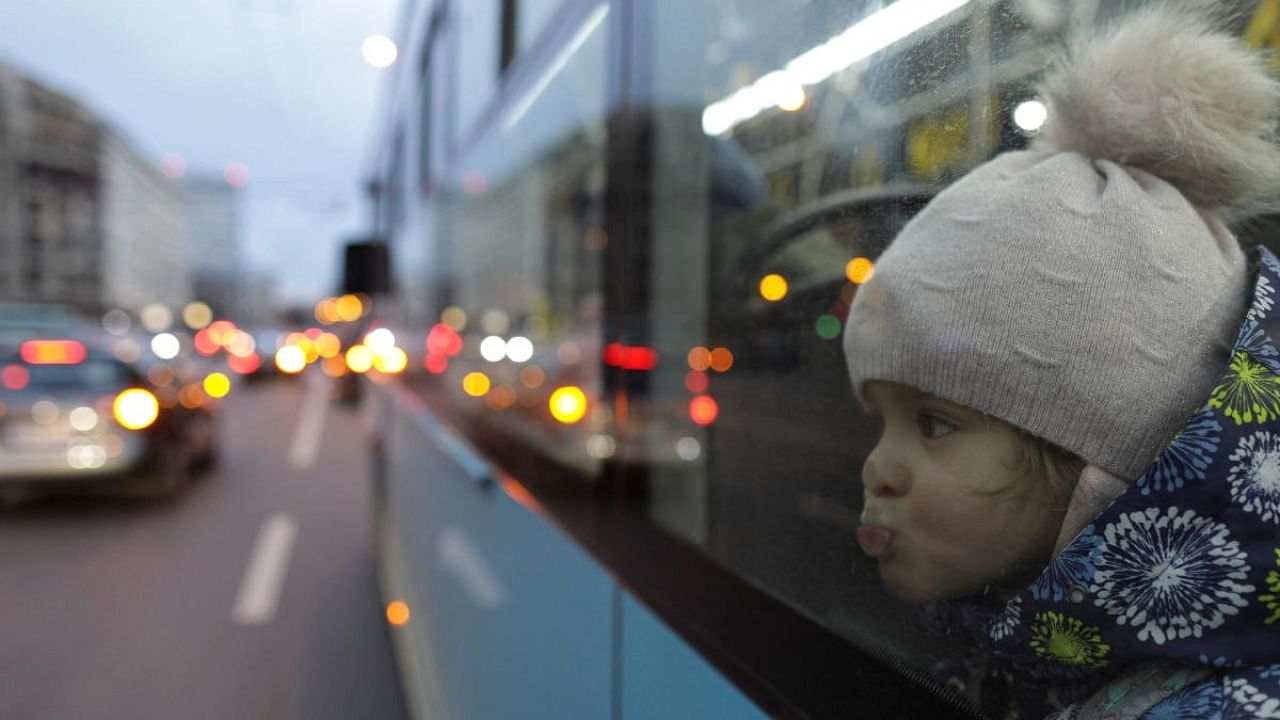 A child puckers her lips on a window of a bus heading to a temporary housing location, following Russian invasion of Ukraine, near the North Railway Station in Bucharest. Credit: Reuters photo
