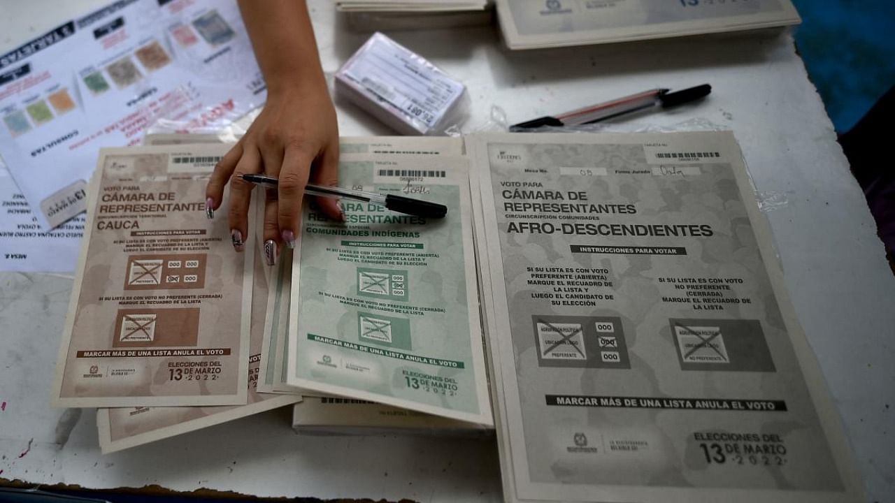 A woman displays electoral cards vote at a polling station during parliamentary elections in Corinto, department of Cauca, Colombia. Credit: AFP Photo