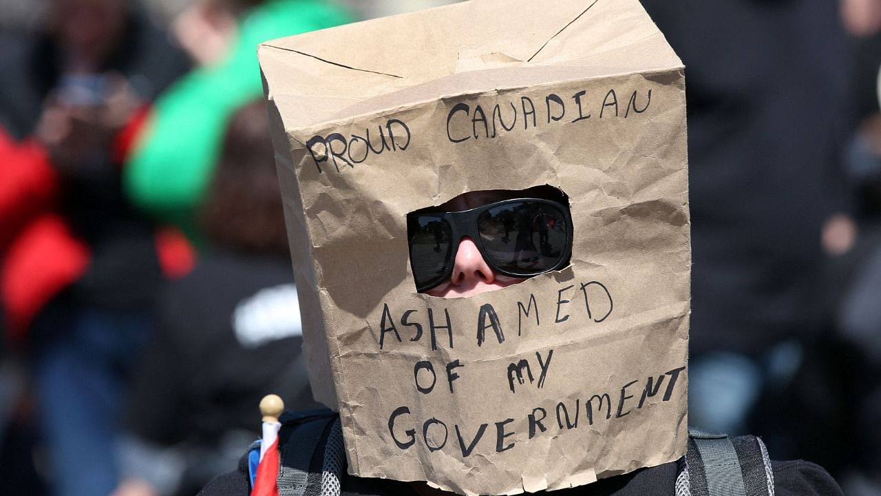 A supporter wears a paper bag at a rally on Parliament Hill during Rolling Thunder Convoy April 30, 2022 in Ottawa, Canada. Credit: AFP Photo