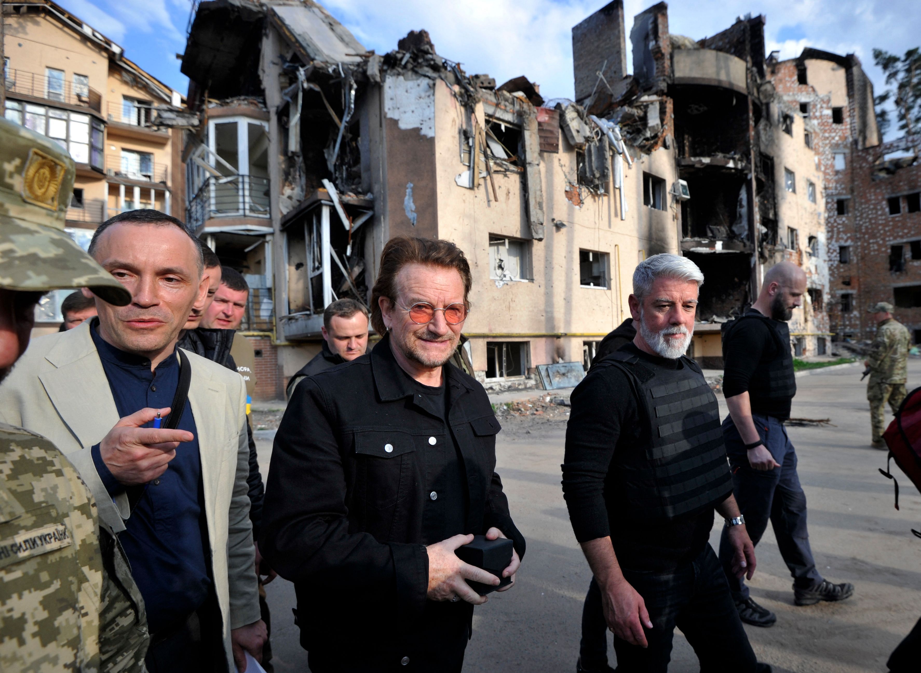 Bono (C) (Paul David Hewson), activist and front man of the Irish rock band U2 inspects the damage to a residential area in the Ukrainian town of Irpin, near Kyiv. Credit: AFP Photo