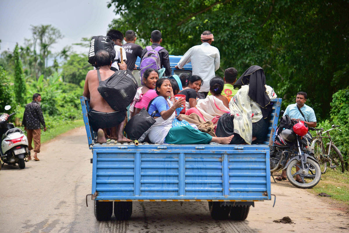 State Disaster Response Force (SDRF) personnel evacuate villagers from a flood-affected village after heavy rainfall, in Nagaon district. Credit: PTI Photo