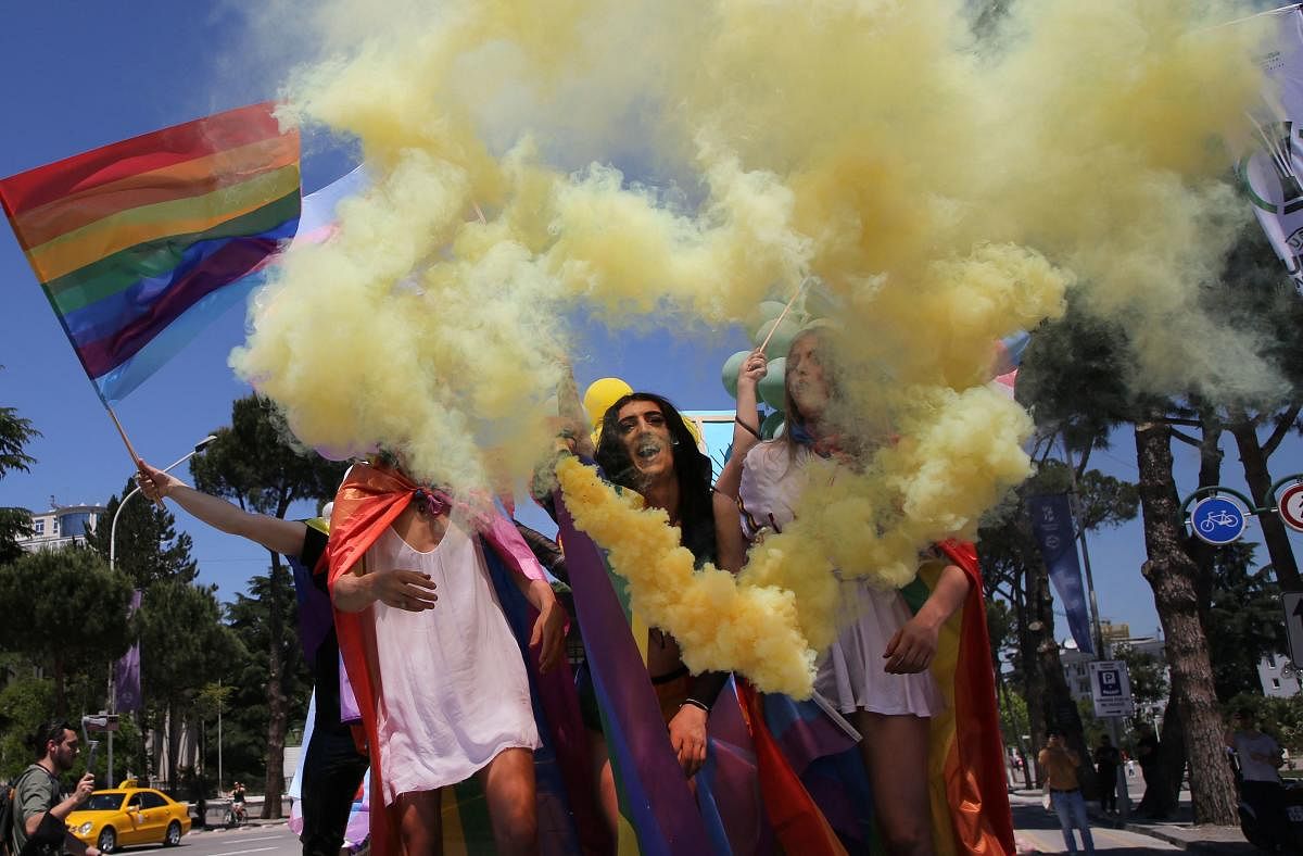 Albanian LGBT activists wave flags and flares as they attend Tirana Gay Pride to mark the International Day Against Homophobia, Transphobia and Biphobia in Tirana. Credit: AFP Photo