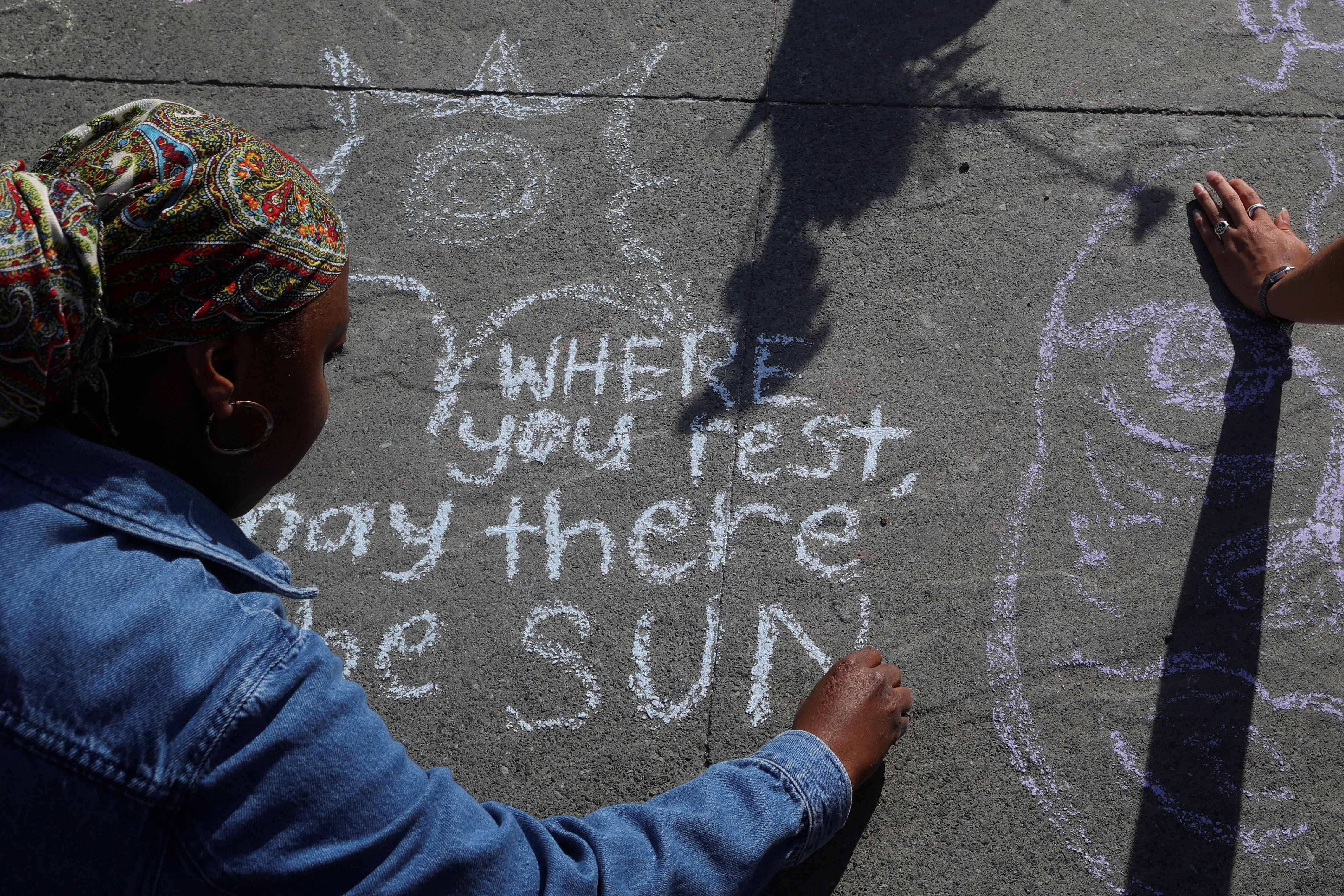 Austyn Jones writes a message for the victims of the mass shooting at the Robb Elementary School in Uvalde, Texas at the "When I Grow Up" memorial service, in Boston. Credit: Reuters Photo