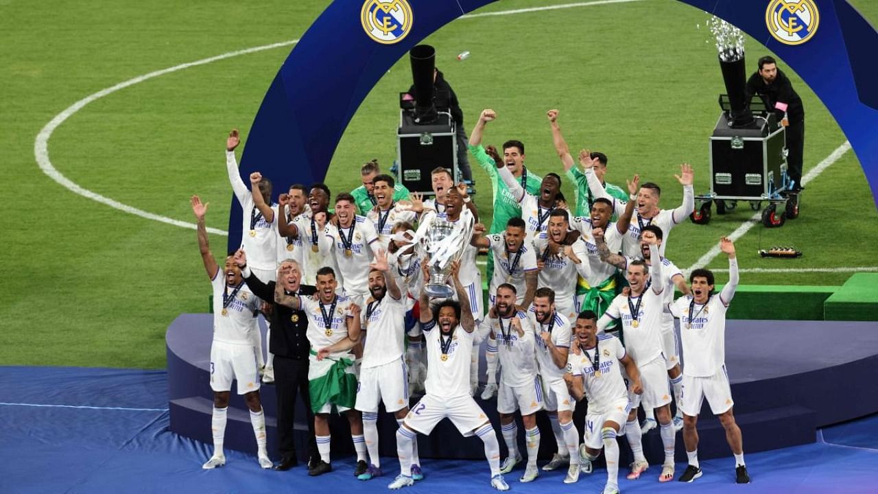 Real Madrid's Brazilian defender Marcelo (C) and his teammates celebrate with the trophy after the UEFA Champions League final football match between Liverpool and Real Madrid at the Stade de France in Saint-Denis. Credit: AFP Photo