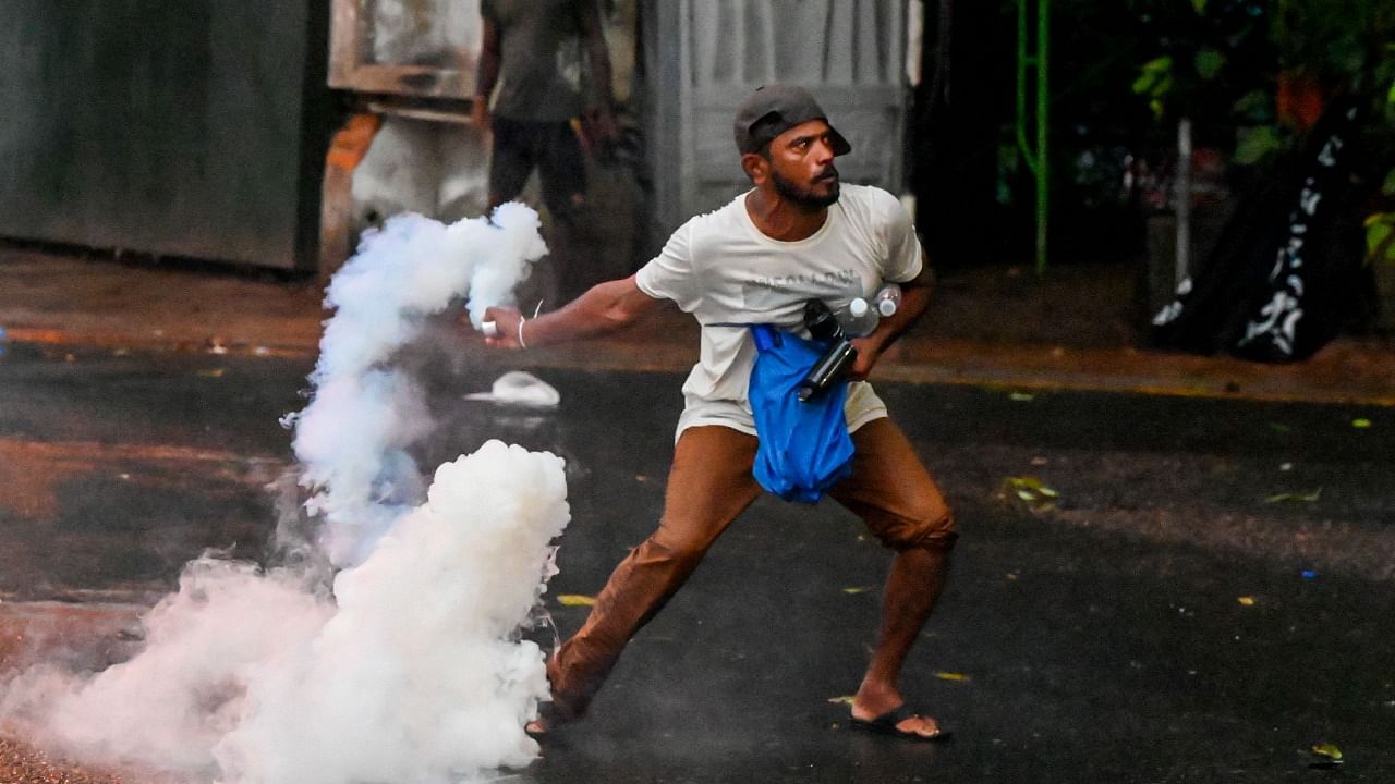 A demonstrator throws back a tear gas canister fired by police to disperse students taking part in an anti-government protest demanding the resignation of Sri Lanka's President Gotabaya Rajapaksa over the country's crippling economic crisis. Credit: AFP Photo
