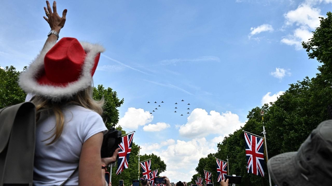 Members of the public cheer as they watch the Royal Air Force Aerobatic Team, the Red Arrows, fly in formation to form the number '70', during the Queen's Birthday Parade, the Trooping the Colour, as part of Queen Elizabeth II's Platinum Jubilee celebrations, in London. Credit: Reuters Photo