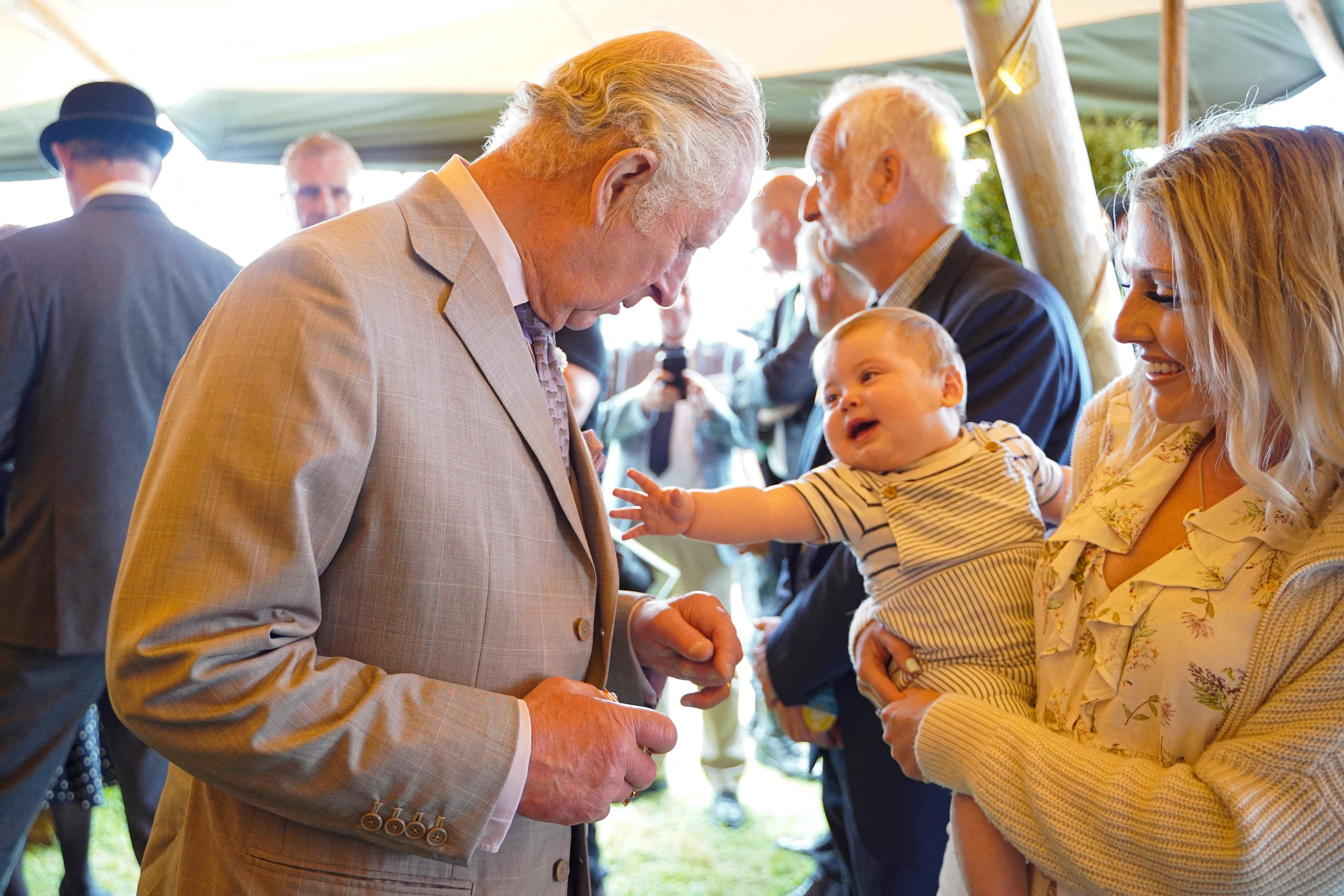 Britain's Prince Charles, Prince of Wales (L) makes a young friend during a visit to the Royal Cornwall Show at The Royal Cornwall Showground in Wadebridge, south west England. Credit: AFP Photo