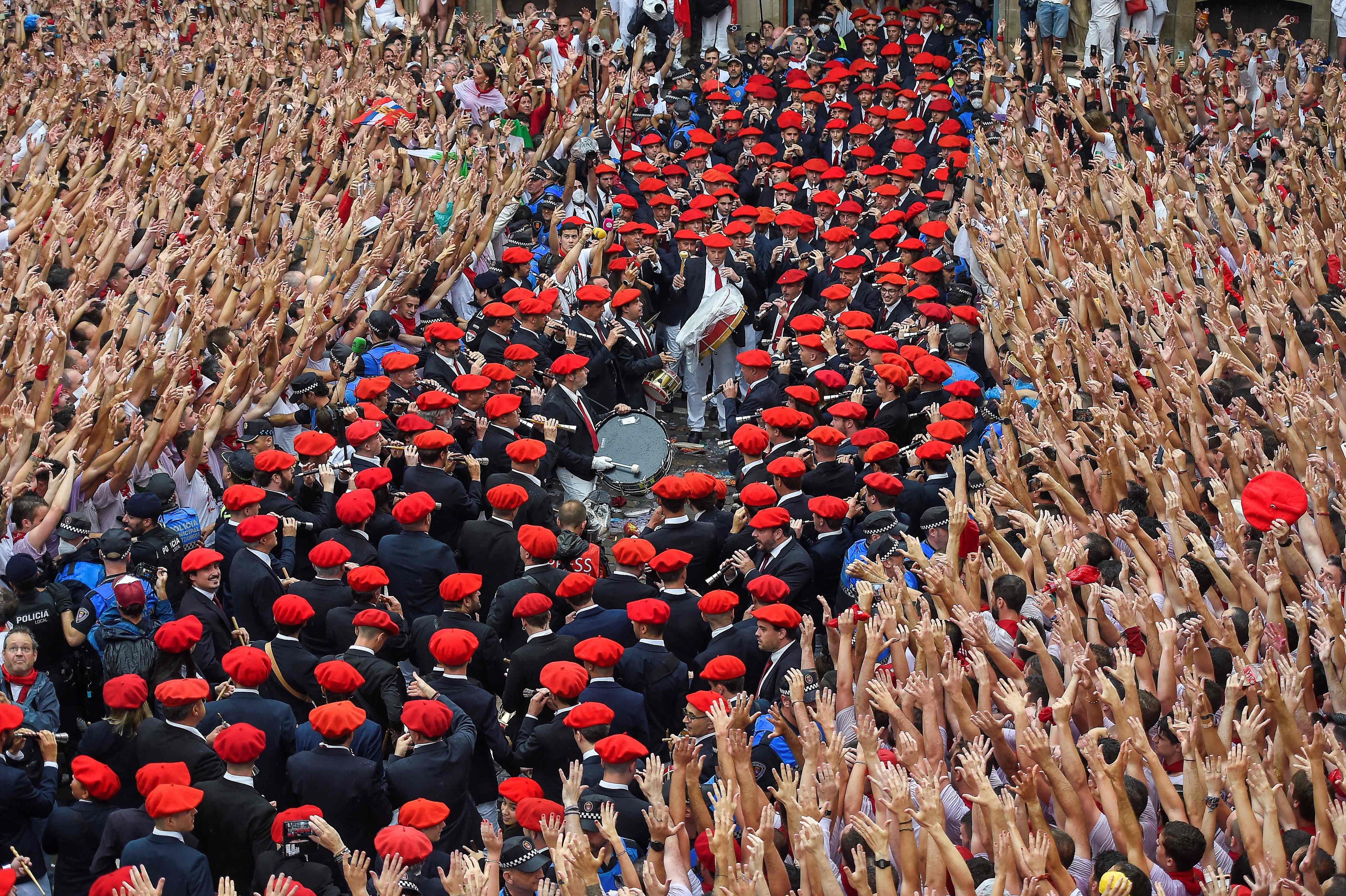 Participants celebrate as the "Pamplonesa" municipal music band performs during the "Chupinazo" (start rocket) opening ceremony to mark the kick-off of the San Fermin Festival outside the Town Hall of Pamplona in northern Spain. Credit: AFP Photo
