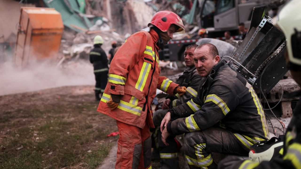 Firefighters rest as their colleagues remove debris to find bodies of people at the Central House of Culture, after a military strike hit a building, as Russia's invasion of Ukraine continues, in Chuhuiv, in Kharkiv region, Ukraine. Credit: Reuters photo