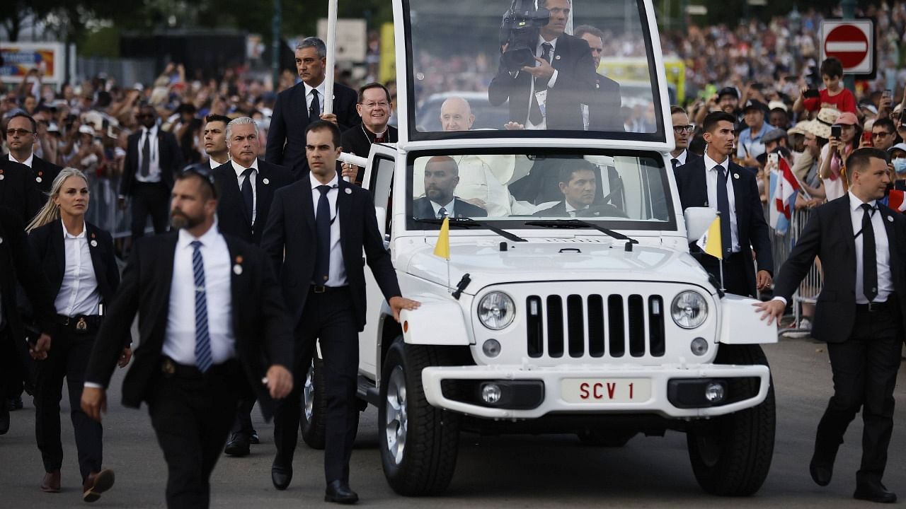 Surrounded by security, Pope Francis rides in the 'Popemobile' as he tours the Plains of Abraham on July 27, 2022 in Quebec, Canada. Credit: AFP Photo