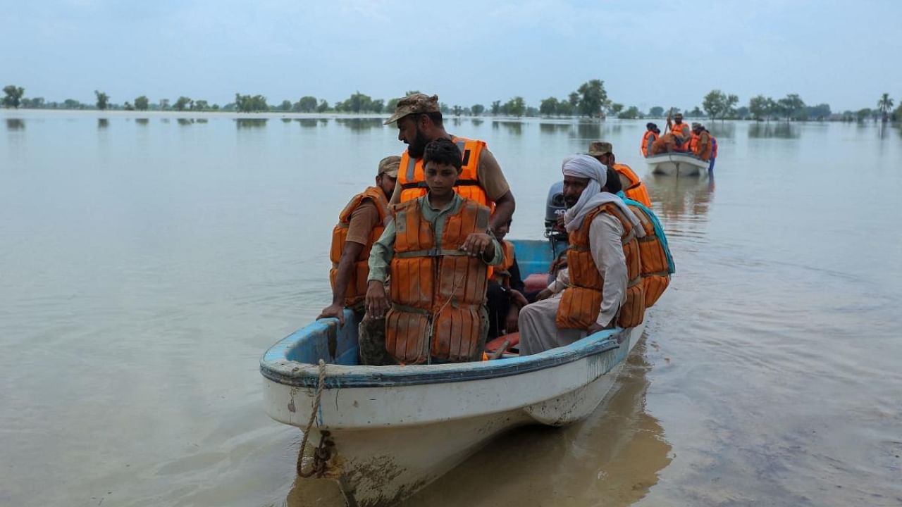Soldiers of Pakistan army rescue people from the flood affected Rajanpur district, in the Punjab province of Pakistan, on August 2, 2022. - Fierce monsoon rains and deadly flooding have hit Pakistan hard this year particularly in Balochistan province, bordering Iran and Afghanistan. At least 478 people have died so far, including 136 in Balochistan. Credit: AFP Photo
