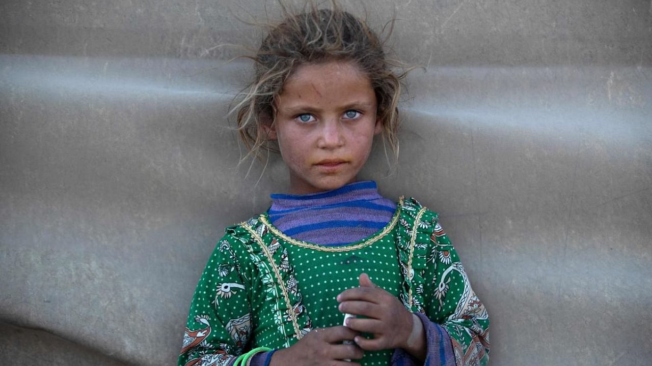 A girl stands at a camp for Syrians displaced by conflict near the Syrian northern city of Raqa on August 2, 2022. Credit: AFP Photo
