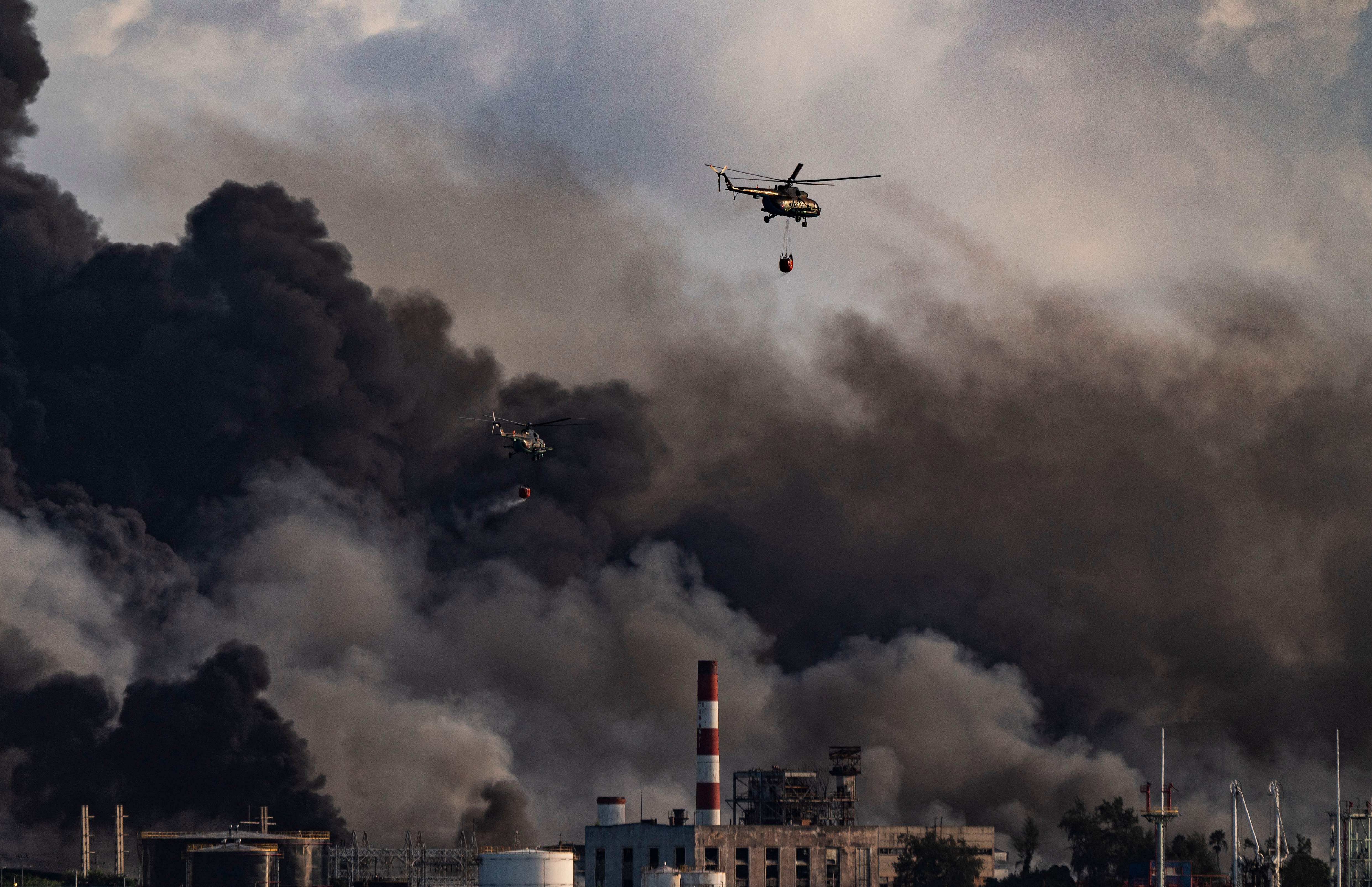 A firefighter helicopter drops water on a massive fire at a fuel depot sparked by a lightning strike in Matanzas, Cuba. Credit: AFP Photo