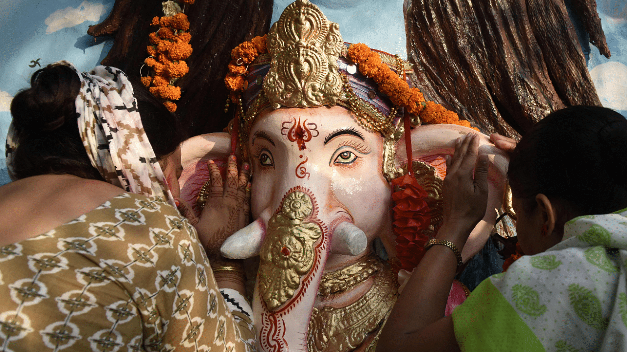 Hindu devotees offer prayers before immersing an idol of the elephant-headed Hindu God Ganesha in a river during the ten-day-long 'Ganesh Chaturthi' festival on the outskirts of Amritsar. Credit: AFP Photo