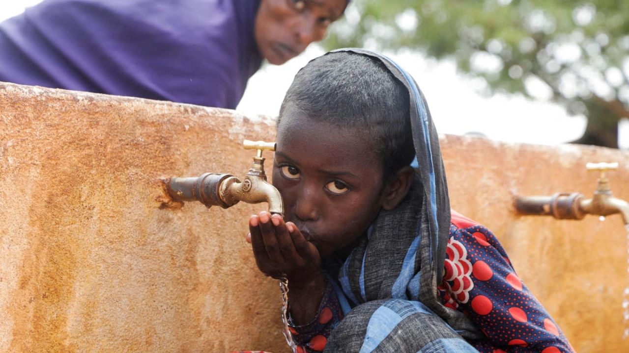Somali displaced girl Sadia Ali, 8, drinks water from a tap at the Kaxareey camp for the internally displaced people in Dollow, Gedo region of Somalia May 24, 2022. Credit: AFP Photo