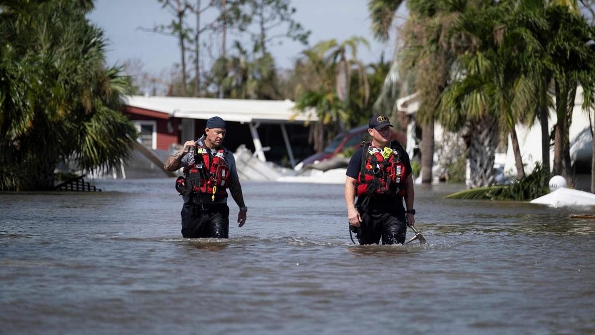 Search and rescue personnel wade through the waters of a flooded neighbourhood as they search for survivors in the aftermath of Hurricane Ian, in Fort Myers, Florida. Credit: AFP Photo