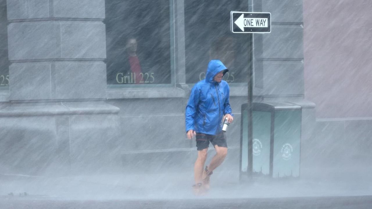 A pedestrian navigates a driving rain from Hurricane Ian on September 30, 2022 in Charleston, South Carolina. Credit: AFP Photo
