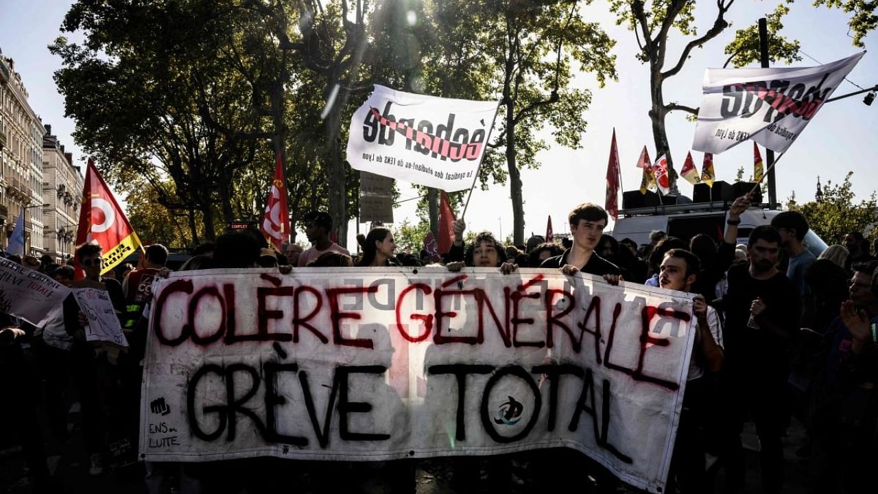 Protesters hold a sign reading 'General anger, total strike' during a demonstration in Lyon, centre France. Credit: AFP Photo