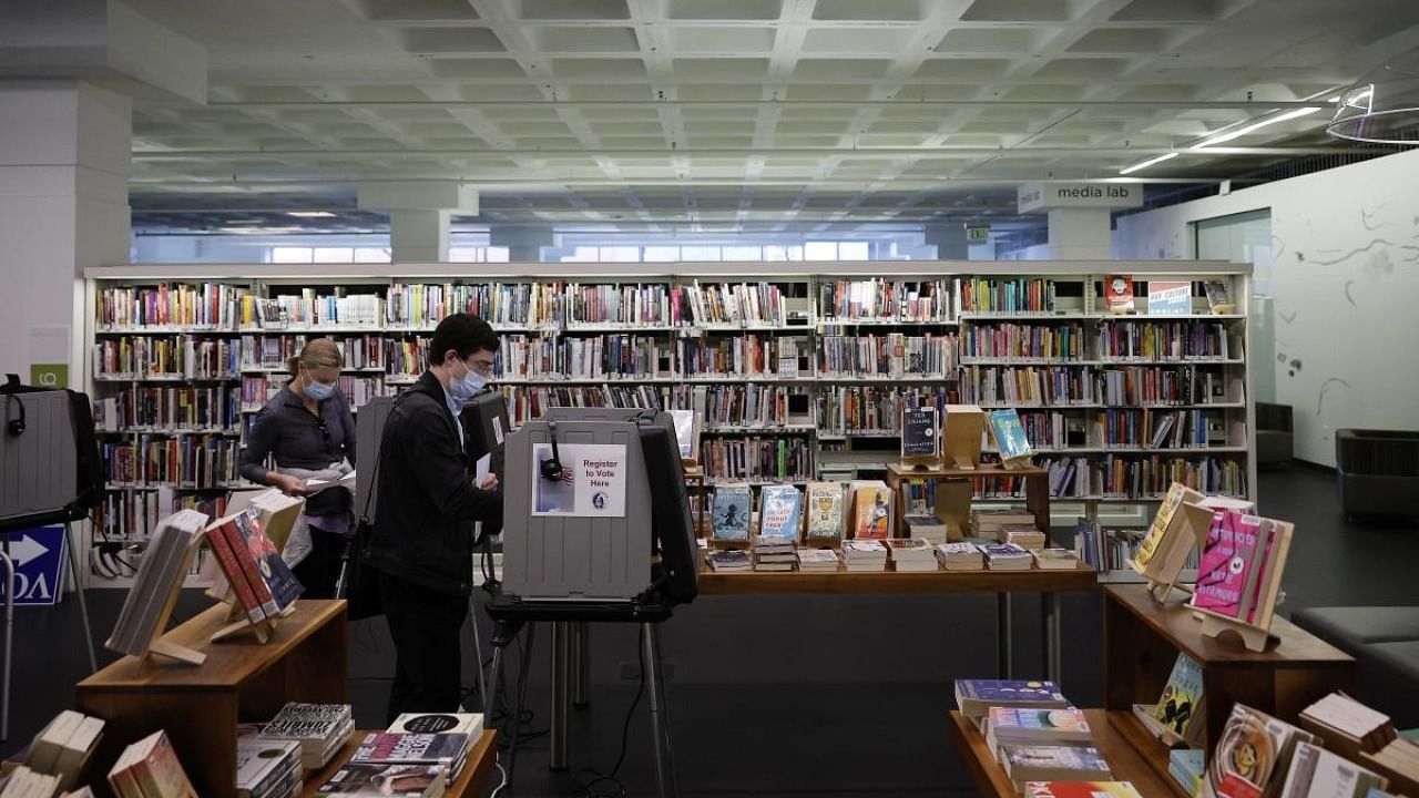 Voters fill out their absentee ballots among the book stacks at the Madison Central Public Library on the last day of early voting in Milwaukee, Wisconsin. Credit: AFP Photo