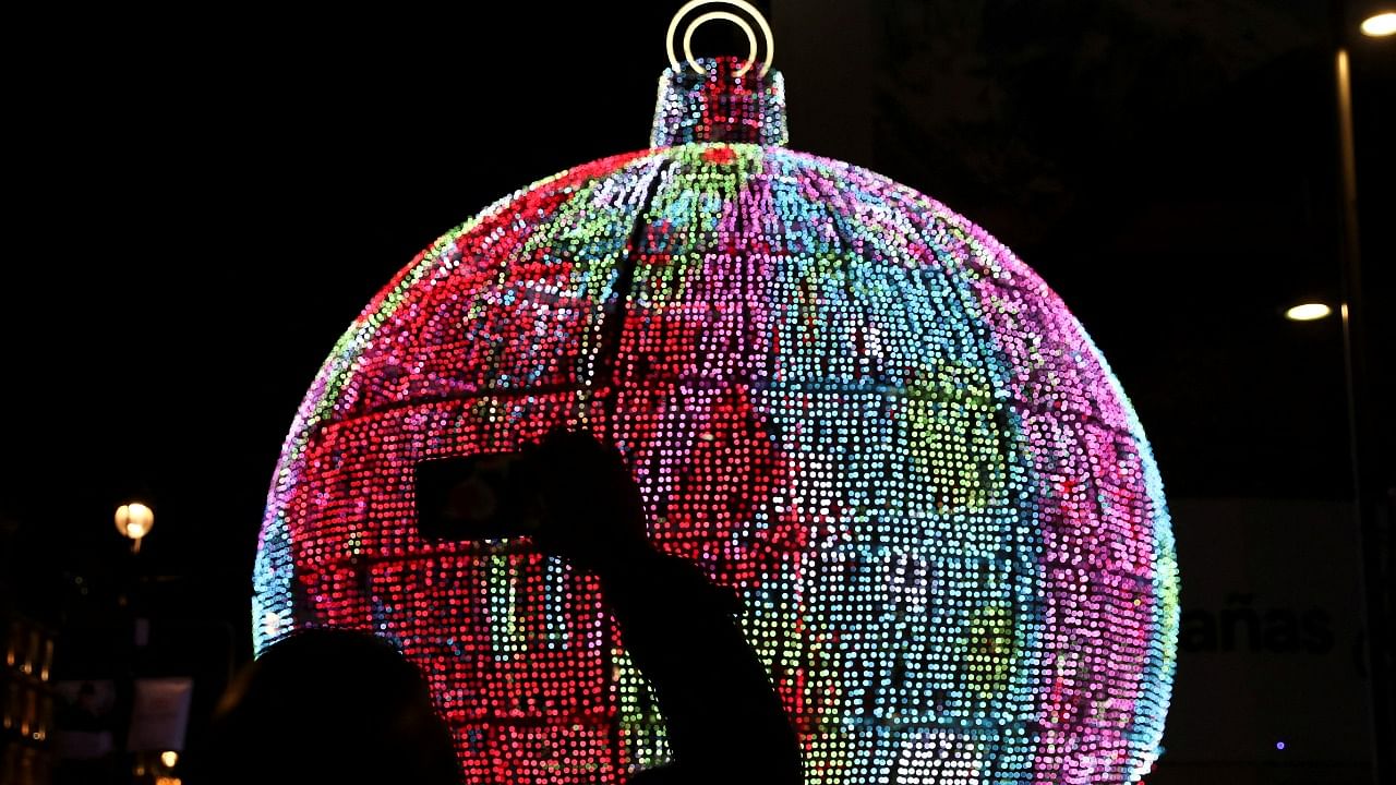 A person takes photos of season decorations on the day that Madrid turns its Christmas lights on. Credit: Reuters Photo