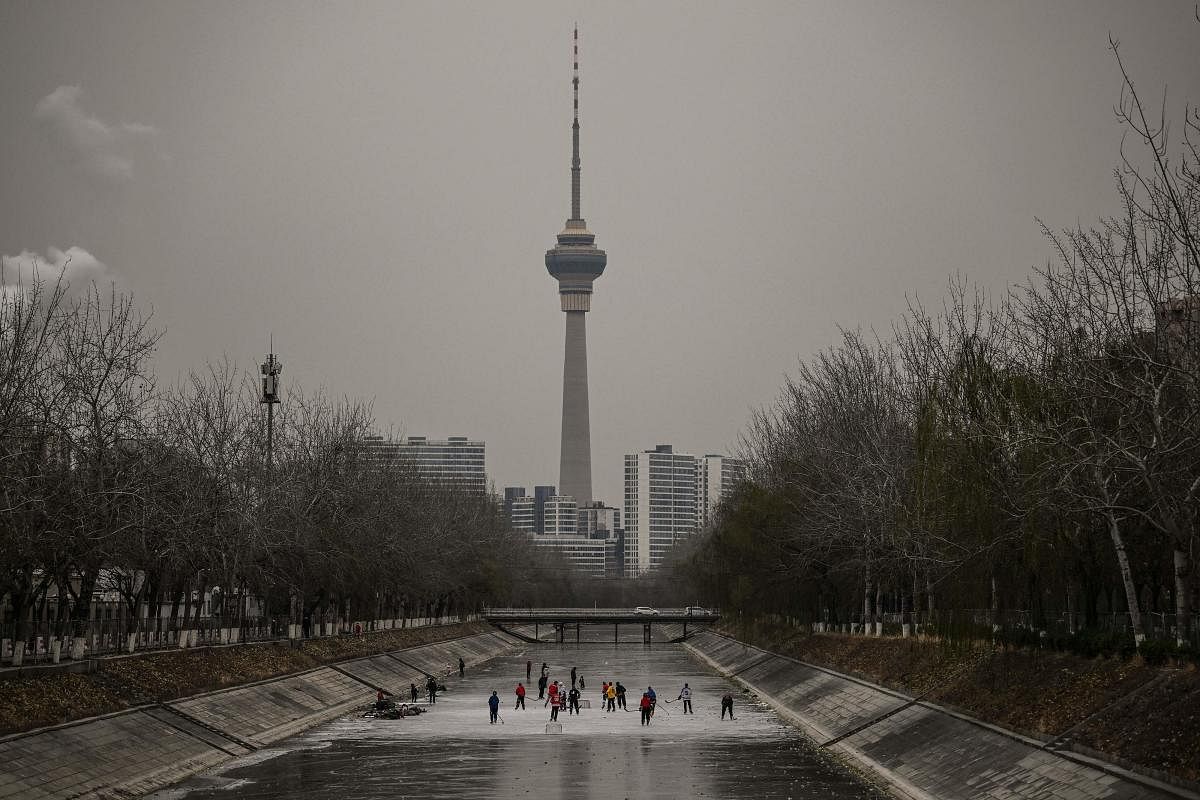 People play ice hockey on a frozen river in Beijing. Credit: AFP Photo