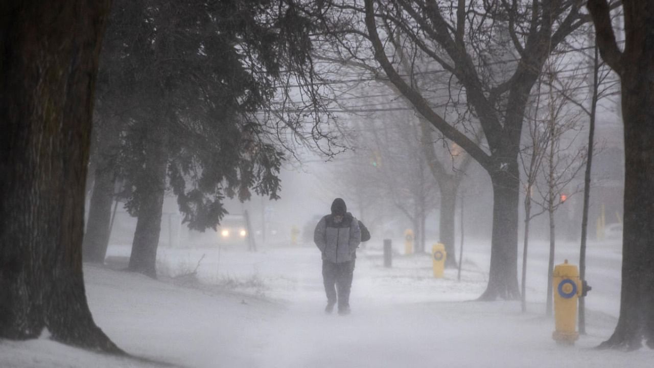 A person walks along a sidewalk during a winter storm in Toronto Ontario, Canada. Credit: Reuters photo