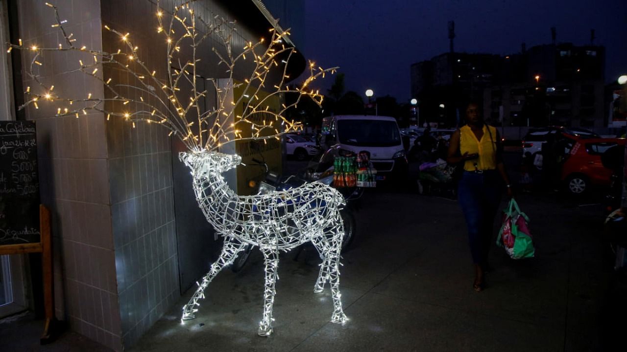 A woman walks past a Christmas reindeer made of lights ahead of the Christmas celebrations in Abidjan, Ivory Coast. Credit: Reuters photo