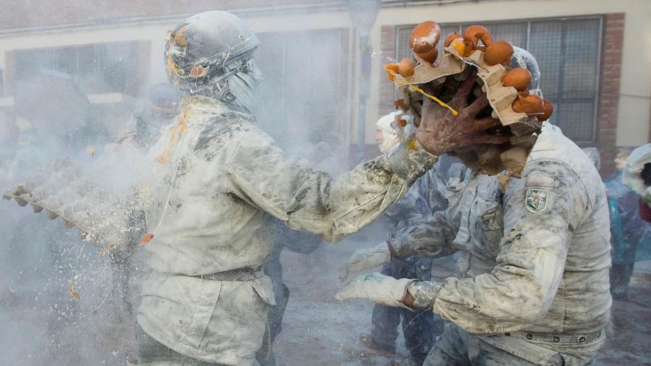 Revellers dressed in mock military garb take part in "Els Enfarinats" food-battle in the southeastern Spanish town of Ibi on December 28, 2022. Credit: AFP Photo
