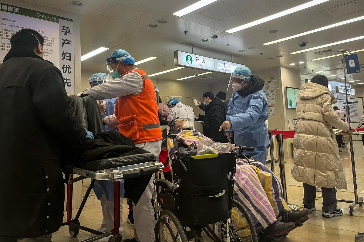 A health worker speaks with a patient on a wheelchair in the emergency department of a hospital in Beijing. Cities across China have struggled with surging infections, a resulting shortage of pharmaceuticals and overflowing hospital wards and crematoriums after Beijing suddenly dismantled its zero-Covid lockdown and testing regime. Credit: AFP Photo