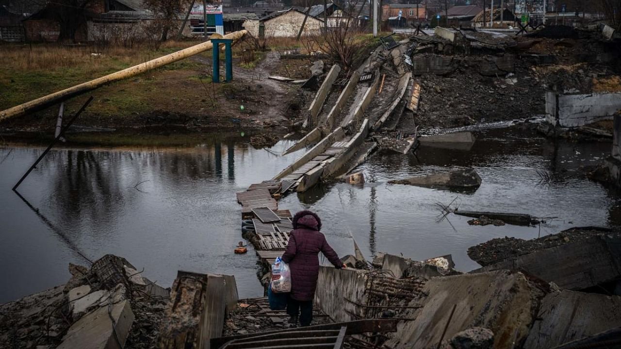 A woman crosses a destroyed bridge in Bakhmut, Donetsk region, on January 6, 2023, amid the Russian invasion of Ukraine. Credit: AFP Photo
