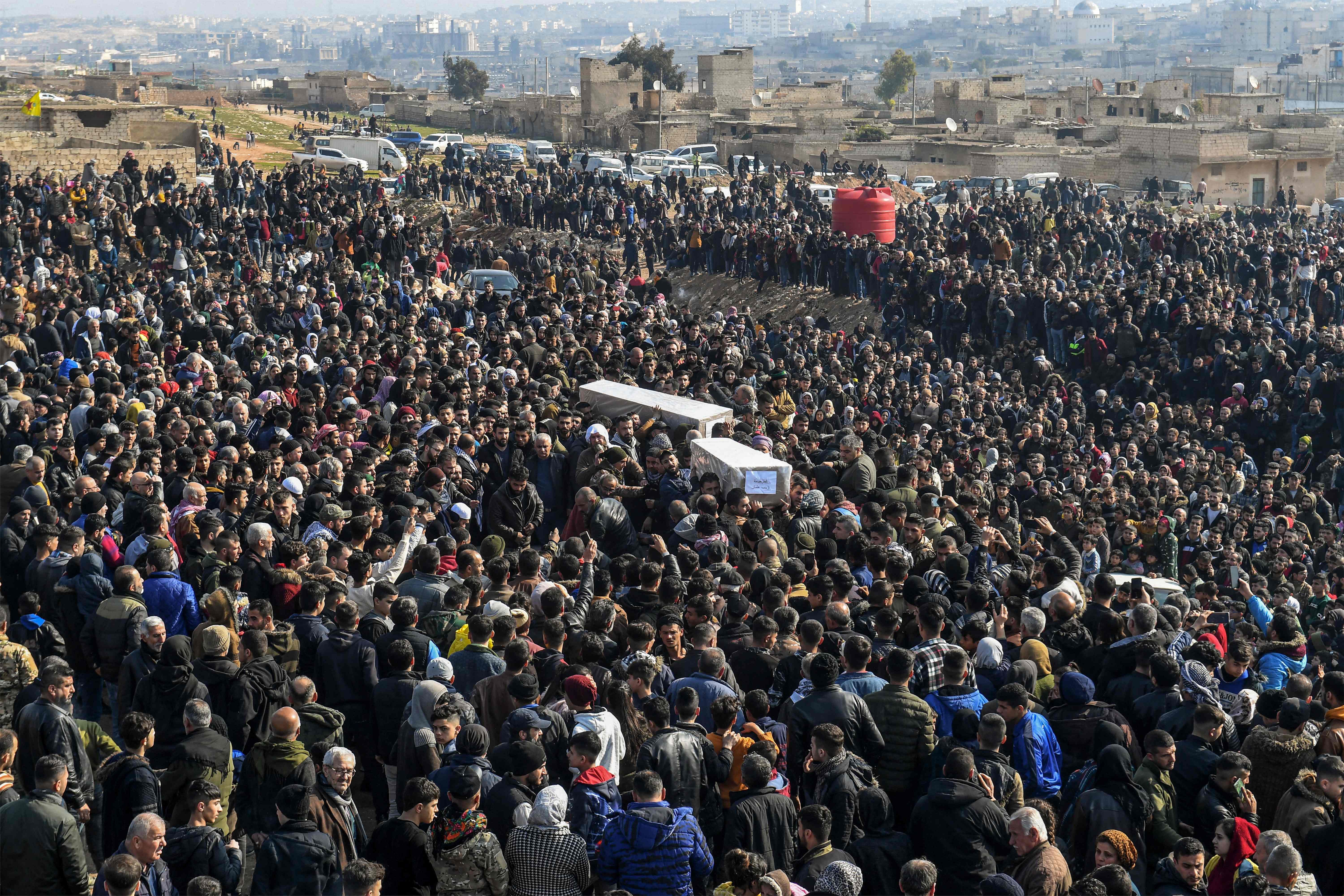 Mourners carry the boxes containing the bodies of victims of a building which collapsed the day before, during the burial in a cemetery in Syria's war-damaged northern city of Aleppo. Credit: AFP Photo