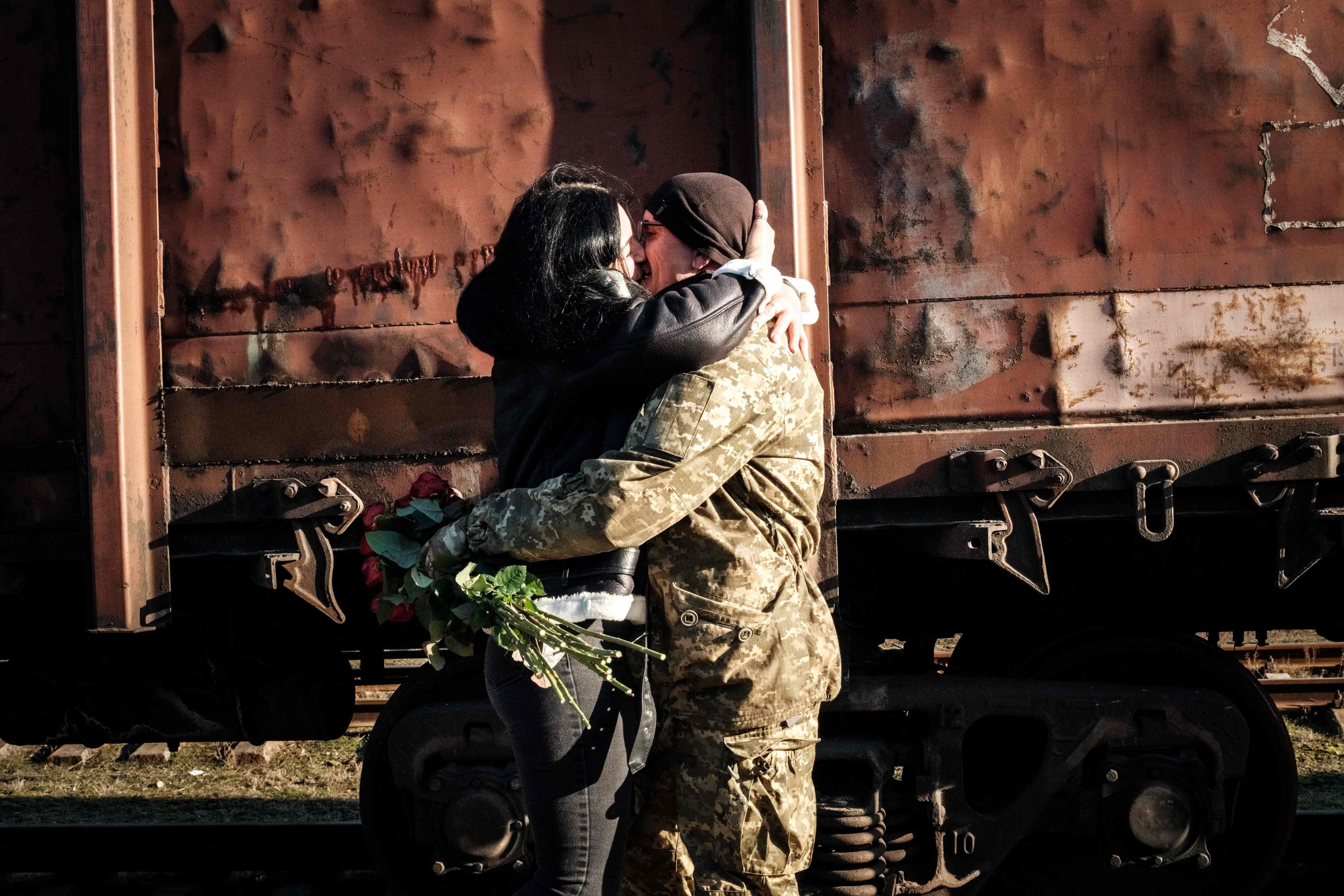 A Ukrainian serviceman embraces his partner upon her arrival from Kyiv at Kramatorsk train station on January 27, 2023, amid the Russian invasion of Ukraine. Credit: AFP Photo