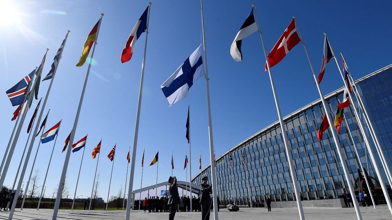 Finnish military personnel install the Finnish national flag at the NATO headquarters in Brussels. Credit: AFP Photo