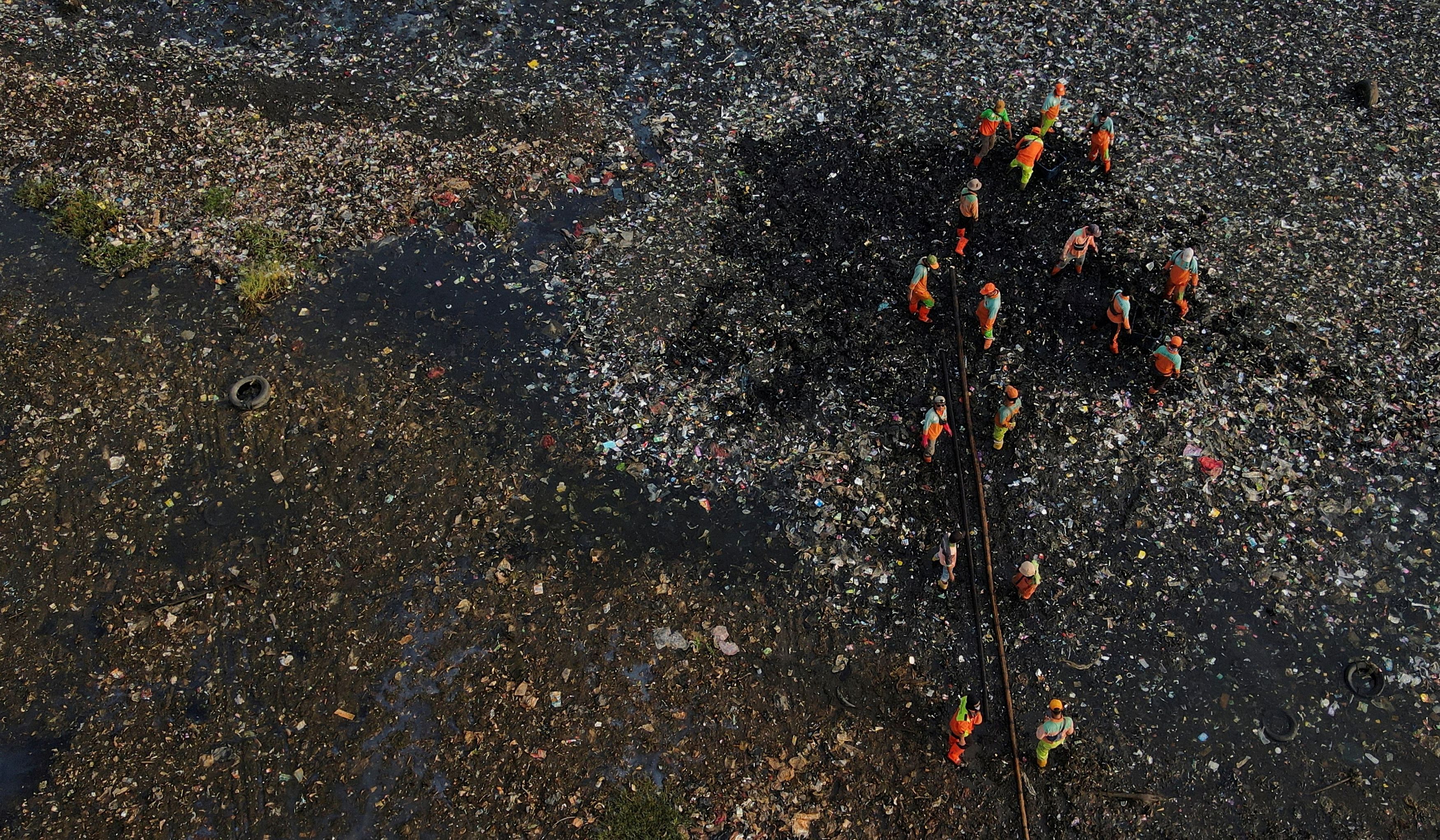 An aerial view show municipality workers collecting garbage, most of which is plastic and domestic waste, during World Oceans Day along the shore of Jakarta. Credit: Reuters Photo