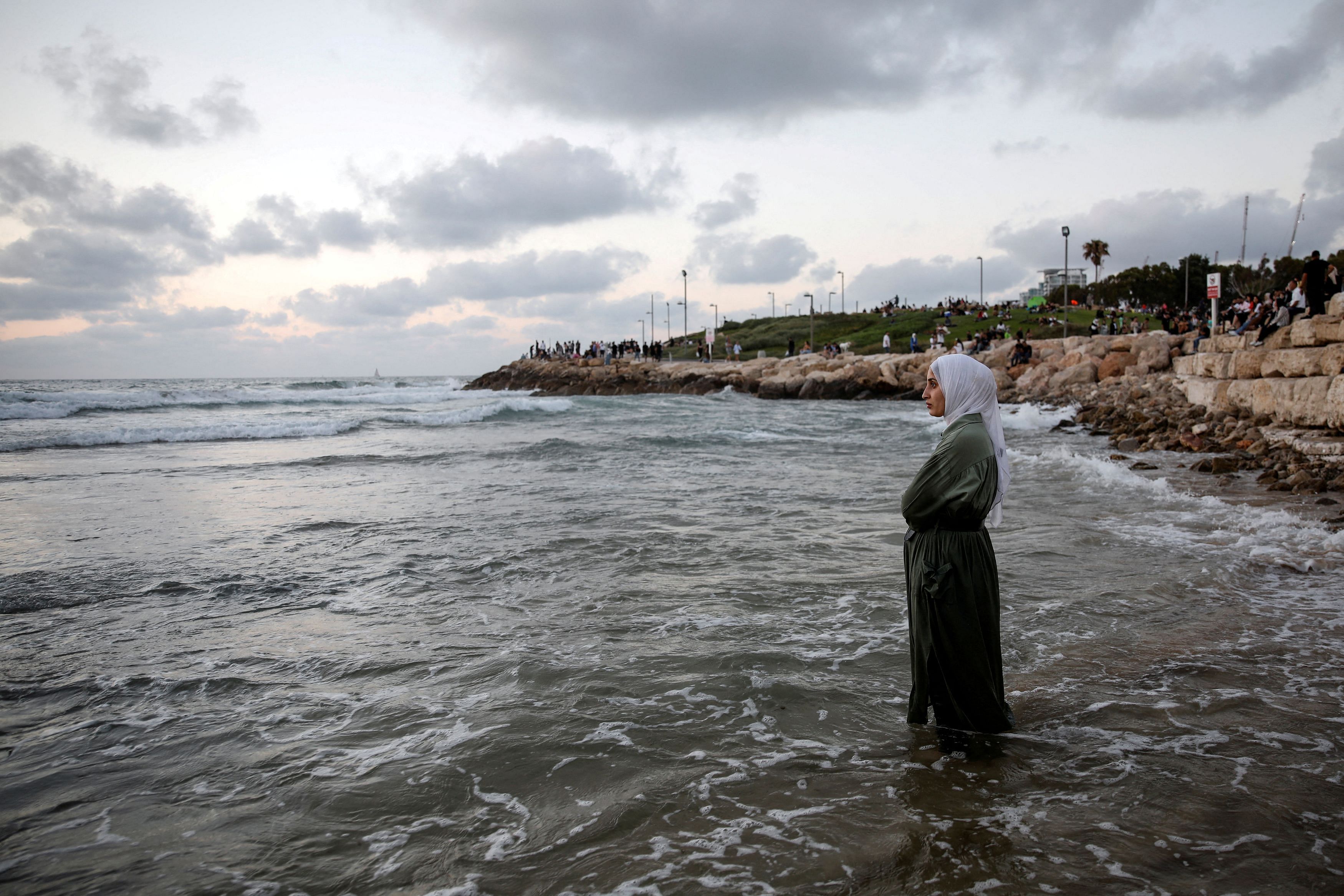 A Palestinian woman stands in the Mediterranean Sea as she visits Tel Aviv during the Muslim holiday of Eid al-Adha in Tel Aviv, Israel. Credit: Reuters Photo