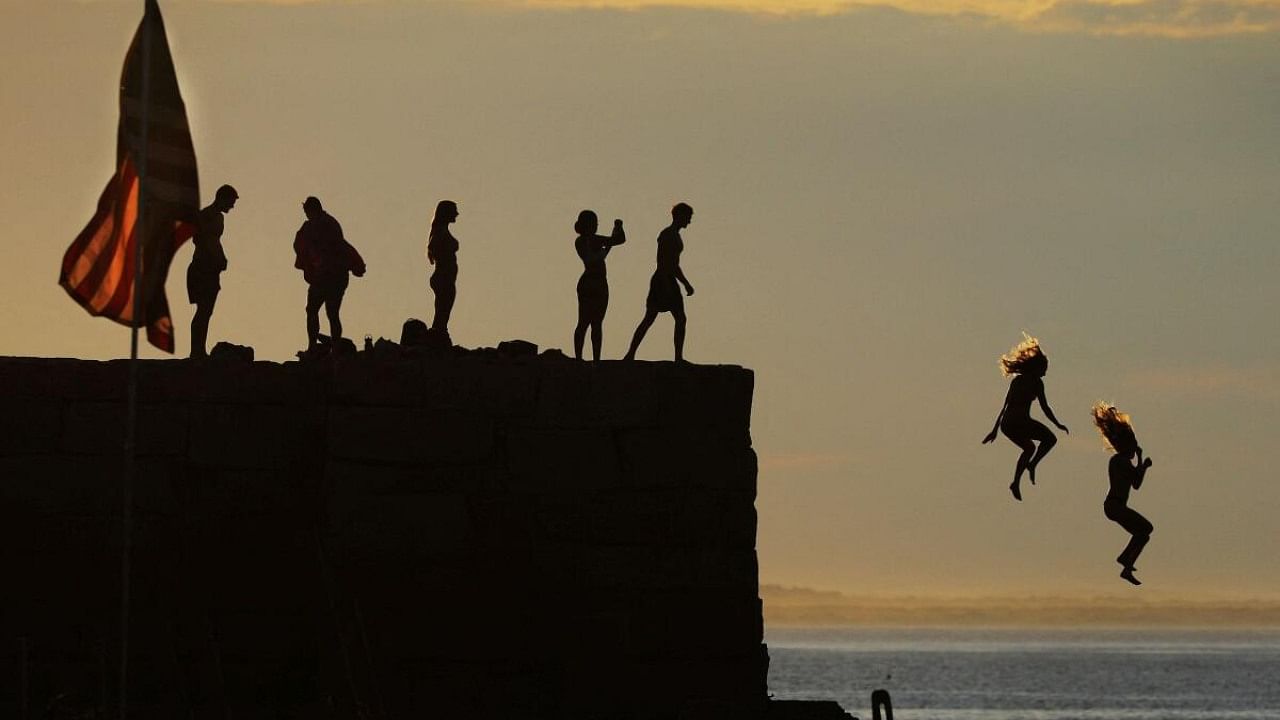 Kids jump off the breakwater into the ocean ahead the Fourth of July holiday in Gloucester, Massachusetts, U.S., July 3, 2023. Credit: Reuters Photo