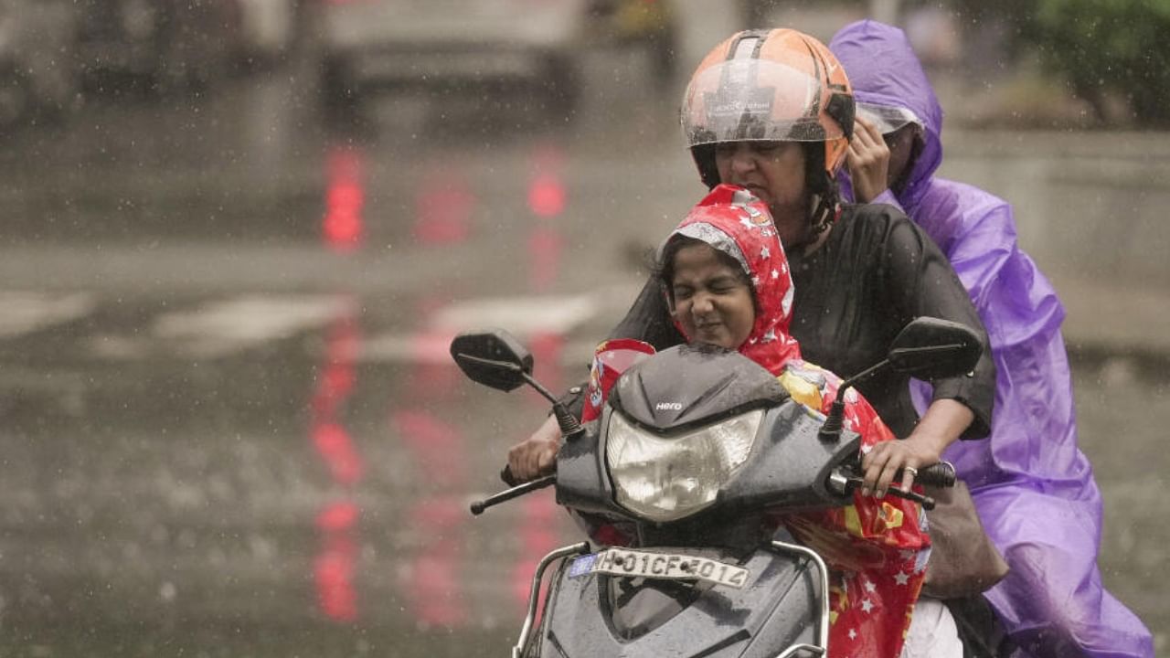 Commuters ride past during monsoon rain, in Mumbai, Wednesday, July 19, 2023. Credit: PTI Photo